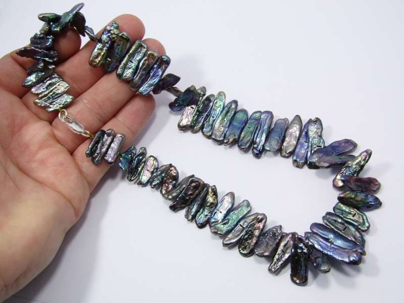 A Beautiful String Of Free Form Peacock Color Pearl Necklace With a Sterling Silver Clasp.