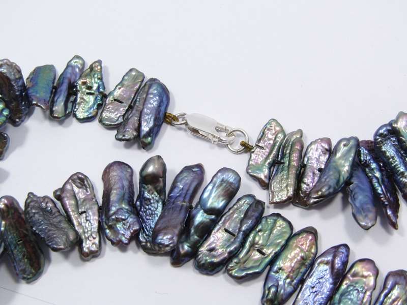 A Beautiful String Of Free Form Peacock Color Pearl Necklace With a Sterling Silver Clasp.