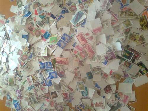 THOUSANDS OF STAMPS IN BOX - OFF PAPER