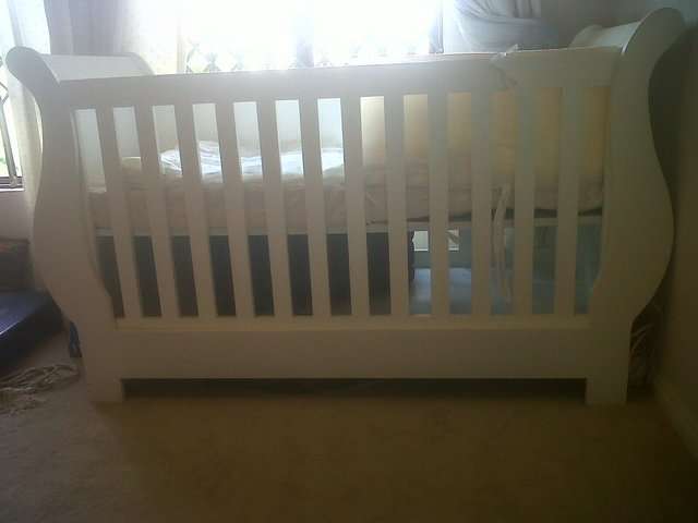 Wooden baby cot with a free compactum, mattress and other accessories thrown in