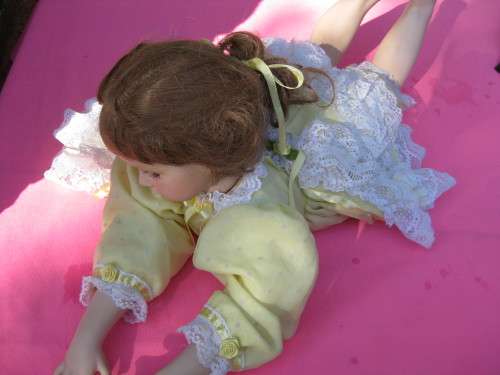Doll lying on her stomach.