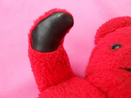 Red `Reindeer` label teddy bear.  Made in South Africa. 400mm high. Hole in right paw and foot.