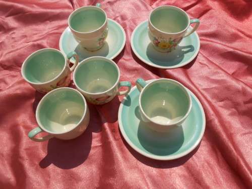 Susie Cooper.  Three saucers and six, SMALL, coffee cups.  No chips, cracks or repairs.