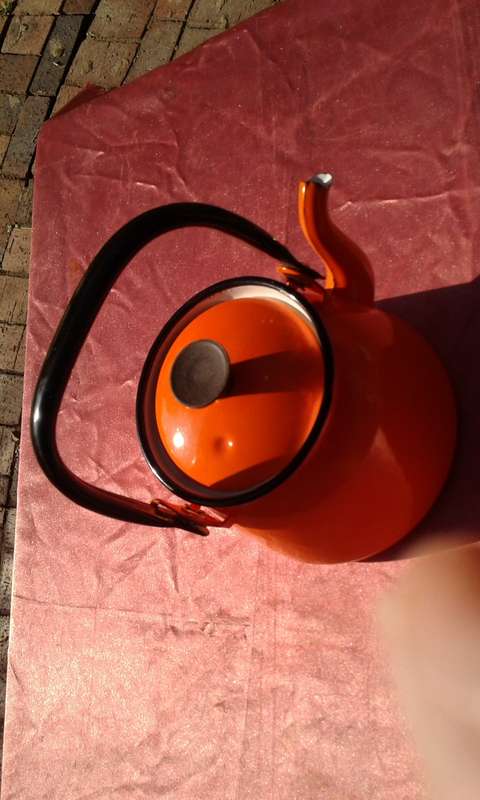 Enamel,  orange-coloured kettle.  Made in Poland.