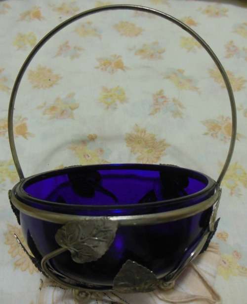 Cobalt blue glass bowl in a metal basket.