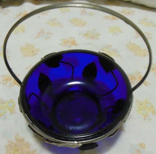 Cobalt blue glass bowl in a metal basket.