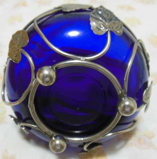 Cobalt blue glass bowl in a metal basket.
