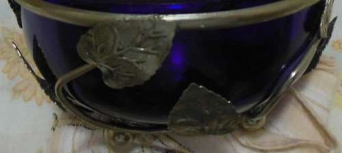 Cobalt blue glass bowl in a metal basket.