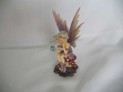 Fairy - sitting on toadstool holding blue crystal - dressed in purple