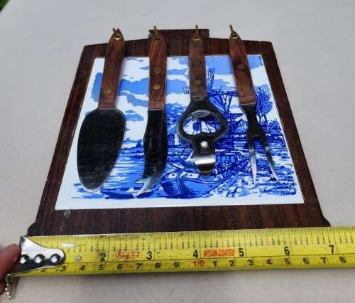 A DUTCH CERAMIC PLATE UTENSIL HOLDER WITH PRONGED CHEESE KNIFE AND SKEWER