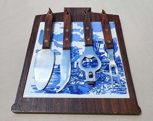 A DUTCH CERAMIC PLATE UTENSIL HOLDER WITH PRONGED CHEESE KNIFE AND SKEWER