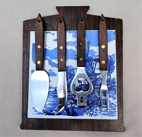 A DUTCH CERAMIC PLATE UTENSIL HOLDER WITH PRONGED CHEESE KNIFE AND SKEWER