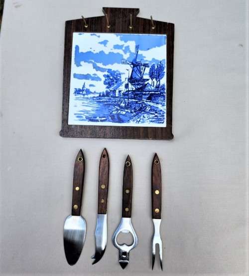 A DUTCH CERAMIC PLATE UTENSIL HOLDER WITH PRONGED CHEESE KNIFE AND SKEWER