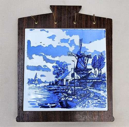 A DUTCH CERAMIC PLATE UTENSIL HOLDER WITH PRONGED CHEESE KNIFE AND SKEWER