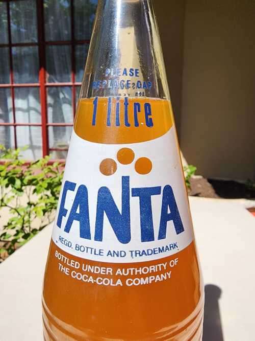 VINTAGE 1970S-1980S RIBBED FANTA 1L GLASS BOTTLE STILL FULL AND UNOPENED LABELS IN ENG AND AFR