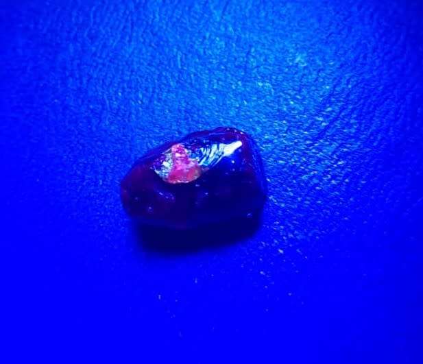 INTERESTING ROUGH 13,50 CARAT PIECE OF COMPOSITE RUBY GEMSTONE WITH RUBY AREA VISIBLE IN RED ON UV!