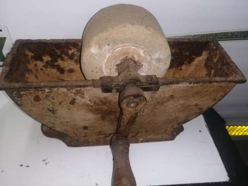 Grinding stone in cast iron holder with handle - very old and with some damage