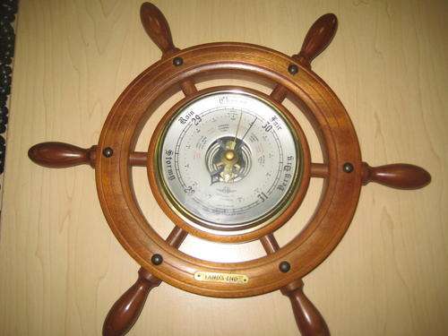 Ships wheel with barometer.