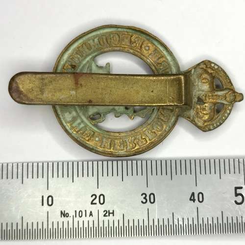 The Hertfordshire regiment cap badge with slide - King`s crown