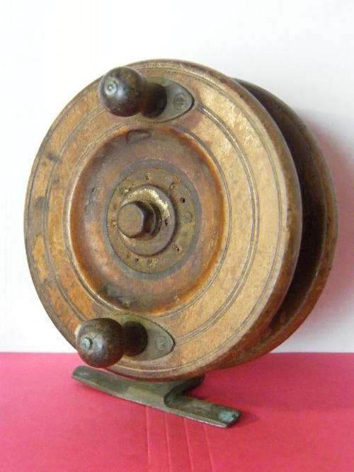 Antique wooden fishing reel with brass foot piece - a bit of the original braid is still on the reel