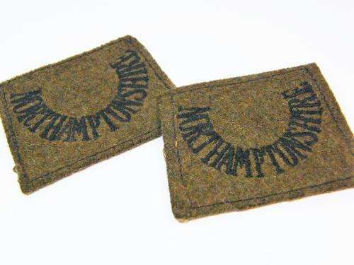 Pair of WW1 Northamptonshire regiment slip on shoulder titles - as per photo