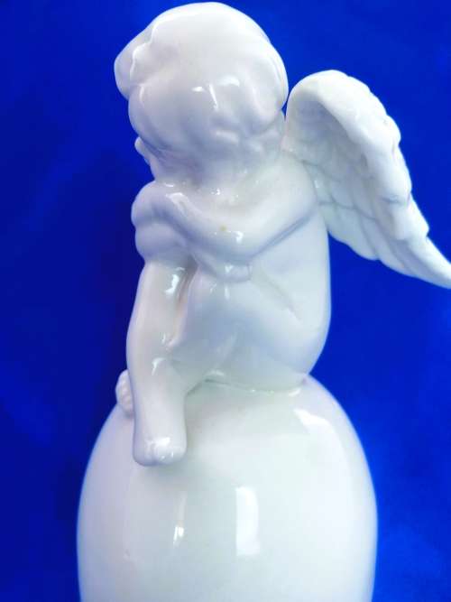 Continental blanc de chine Bell with Cherub sat on top