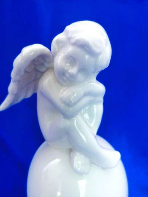Continental blanc de chine Bell with Cherub sat on top