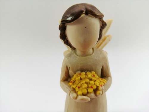 Willow Tree style wooden angel holding yellow flowers