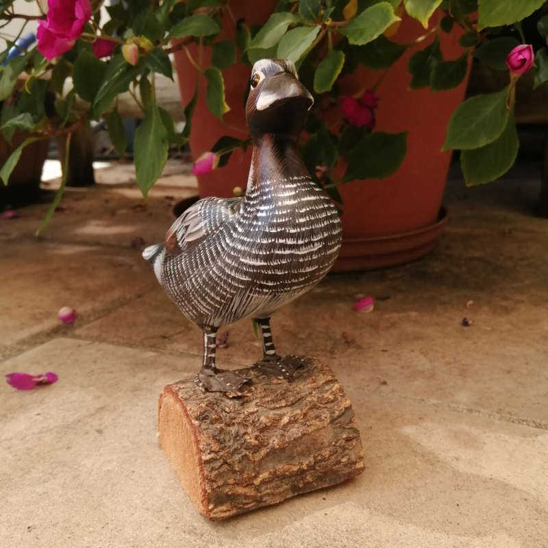 Wooden Hand carved Duck standing on a Log