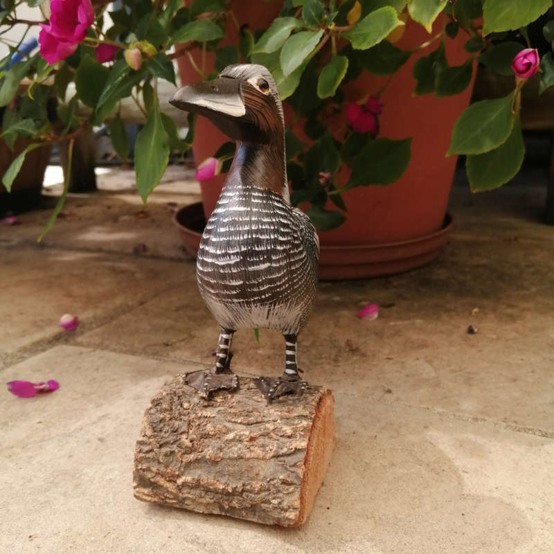 Wooden Hand carved Duck standing on a Log