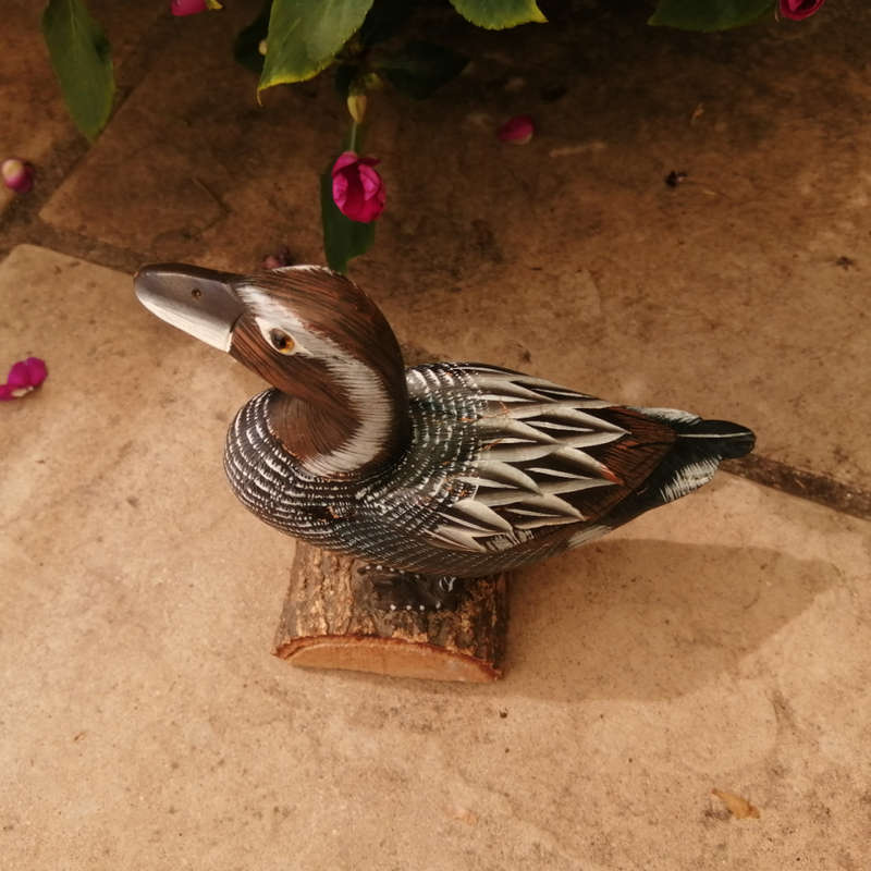 Wooden Hand carved Duck standing on a Log