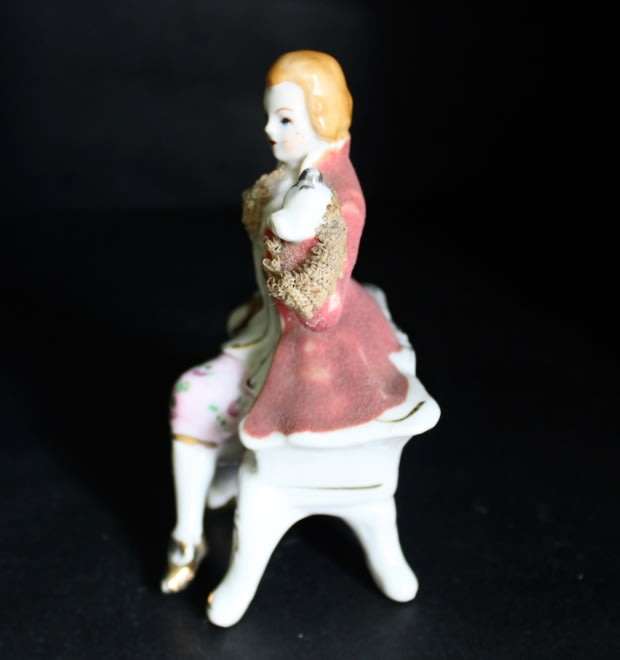 Porcelain Figurine of Man on Seat.