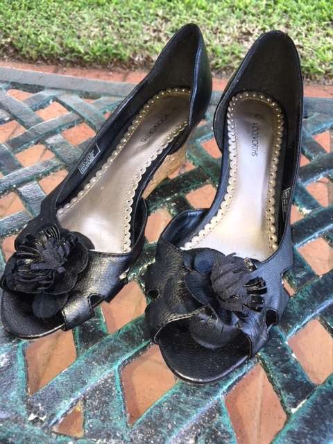 Black low cork wedge heels with open toe and pom pom flowers