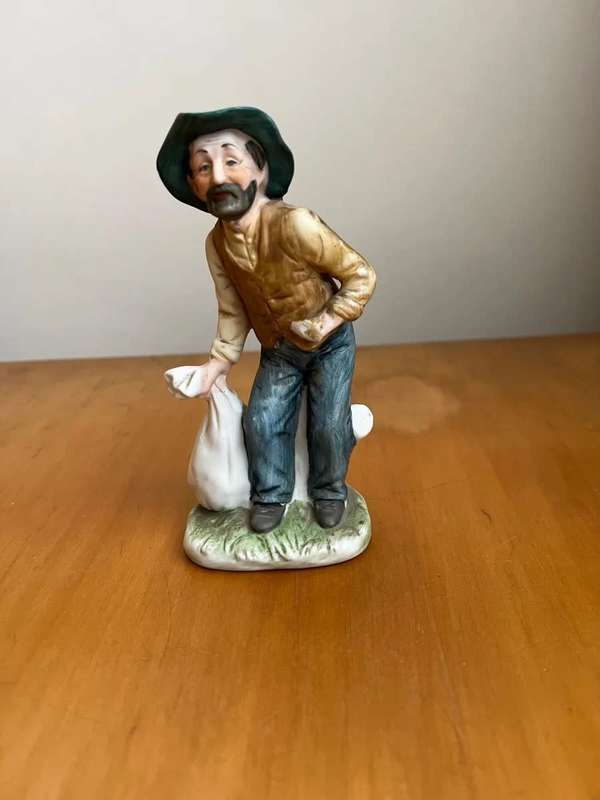 Antique porcelain statue - man carrying bag