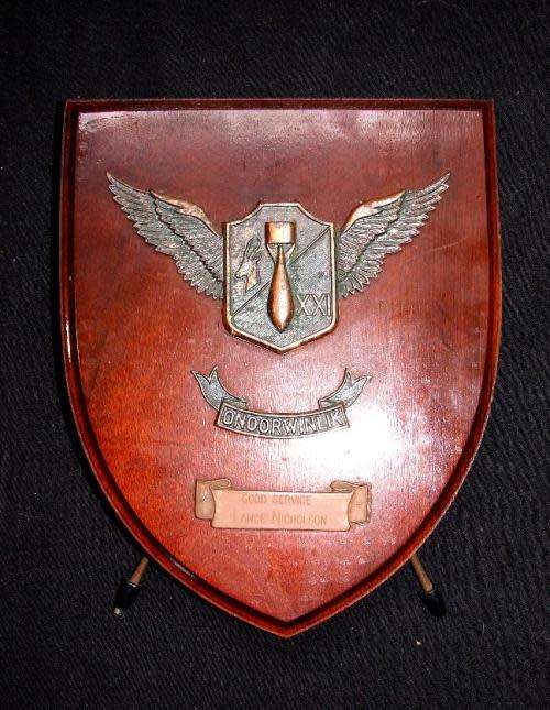 Metal on a wooden shield of the 21st Bomber/VIP squadron presented to Lance Nicholson for good servi