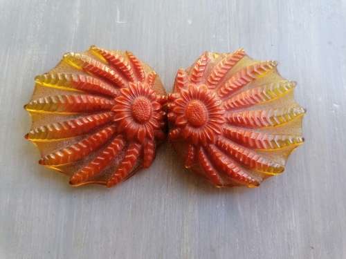 AN ART DECO LUCITE / BAKELITE TYPE FLORAL MOTIF BELT BUCKLE