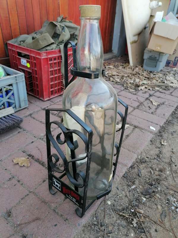Large White Horse whiskey bottle on a stand.