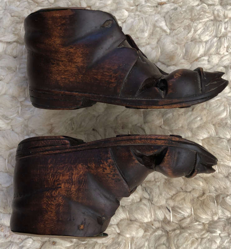 CARVED ANTIQUE PAIR OF WOODEN BOOTS WITH BRASS INSERT