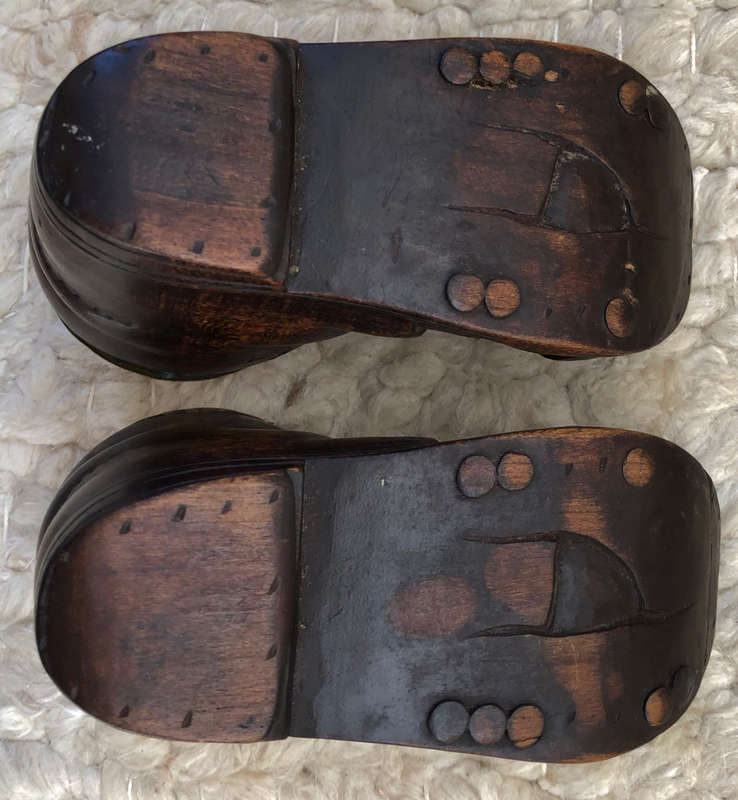 CARVED ANTIQUE PAIR OF WOODEN BOOTS WITH BRASS INSERT