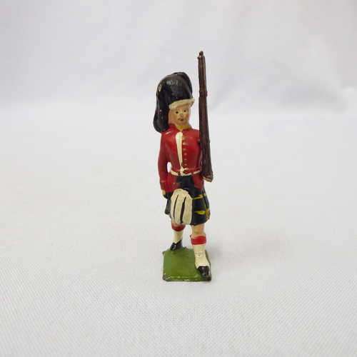 Vintage Scottish lead soldier marching with rifle