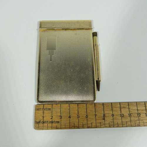 Vintage gold colored pocket notebook with pencil