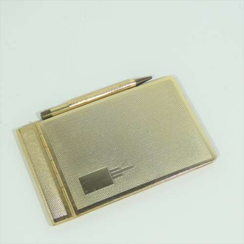 Vintage gold colored pocket notebook with pencil