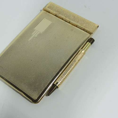 Vintage gold colored pocket notebook with pencil