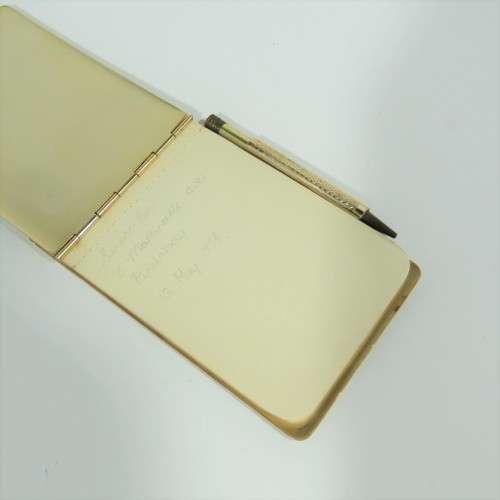 Vintage gold colored pocket notebook with pencil