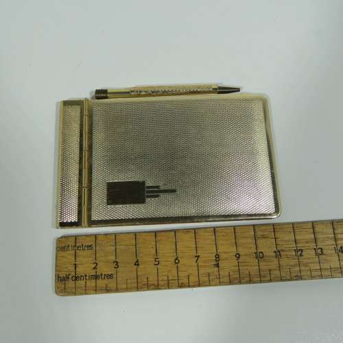 Vintage gold colored pocket notebook with pencil