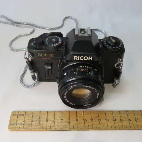 Ricoh KR-10 camera in pouch with Rikenon 1:2 50 mm lens and booklets