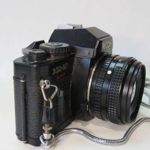Ricoh KR-10 camera in pouch with Rikenon 1:2 50 mm lens and booklets