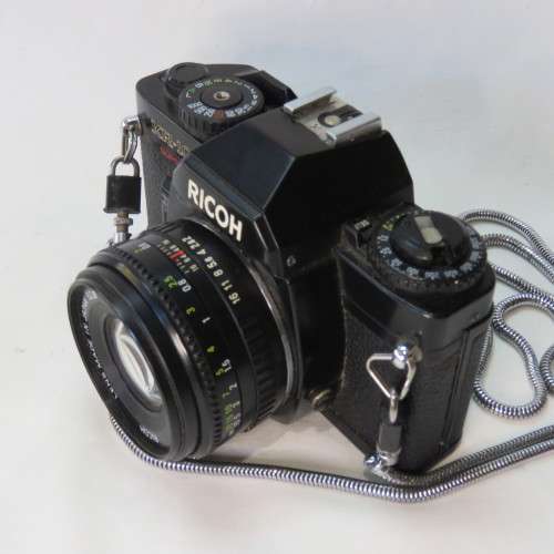 Ricoh KR-10 camera in pouch with Rikenon 1:2 50 mm lens and booklets