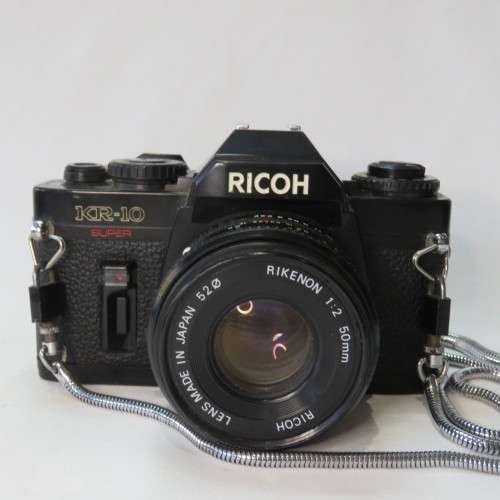 Ricoh KR-10 camera in pouch with Rikenon 1:2 50 mm lens and booklets