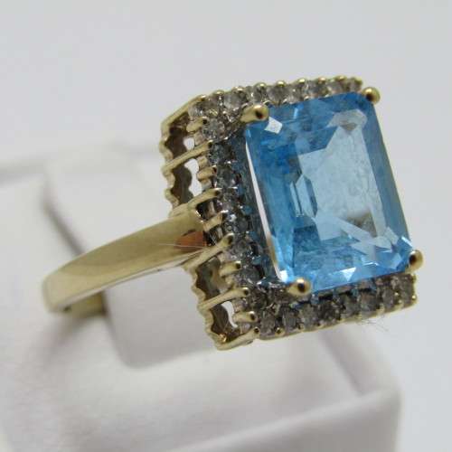 9kt Gold ring with 3.5ct blue topaz and small diamonds of 0.28ct in total - weighs 4.8g - size O/7